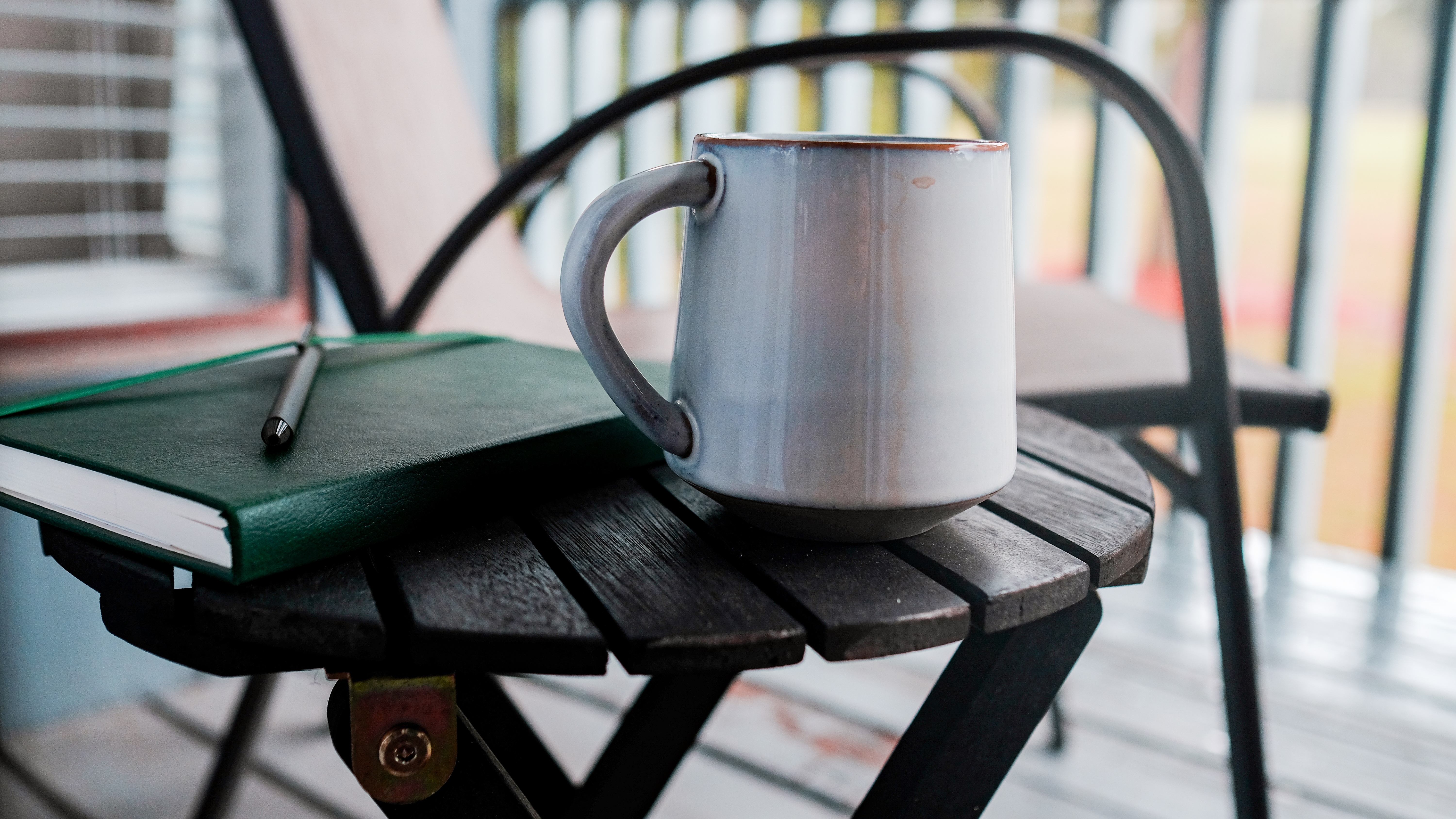 Warm mug beside a journal and pen, representing personal reflection on family-of-origin patterns and emotional wellbeing.