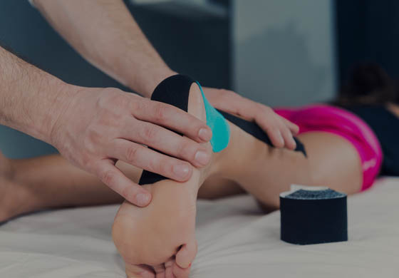 Hand of athletic therapist taping the ankle/heel of a female patient