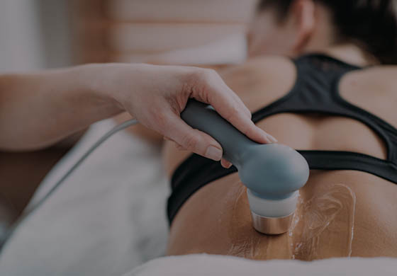 Young female athlete getting ultrasound therapy on her lower back